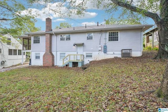 rear view of property featuring a lawn, a sunroom, and cooling unit