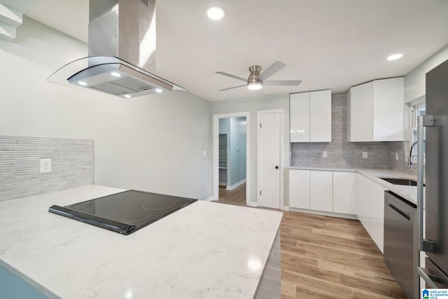 kitchen featuring light hardwood / wood-style flooring, tasteful backsplash, white cabinetry, island exhaust hood, and stainless steel appliances