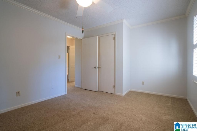 unfurnished bedroom with a textured ceiling, light colored carpet, ceiling fan, and ornamental molding