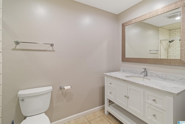 bathroom with tile patterned flooring, vanity, toilet, and tiled shower