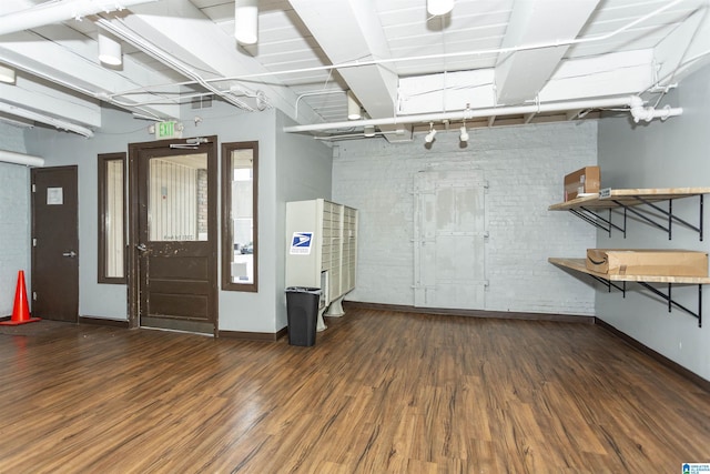 2301 1st Ave N Unit 203, Birmingham, AL 35203 - basement with wood finished floors, brick wall, and baseboards