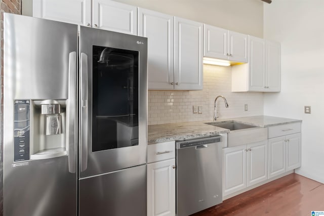 kitchen with white cabinetry, appliances with stainless steel finishes, sink, and decorative backsplash