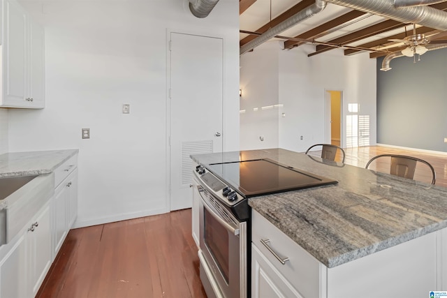 kitchen featuring white cabinetry, stainless steel range with electric cooktop, dark wood-type flooring, and light stone counters