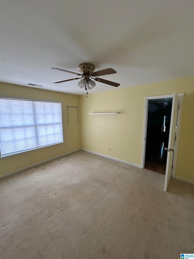 spare room featuring ceiling fan and light carpet