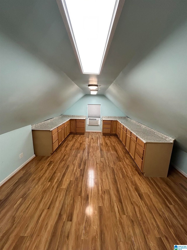 additional living space featuring wood-type flooring and lofted ceiling