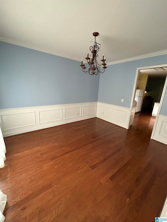 unfurnished dining area featuring dark hardwood / wood-style flooring, a chandelier, and ornamental molding