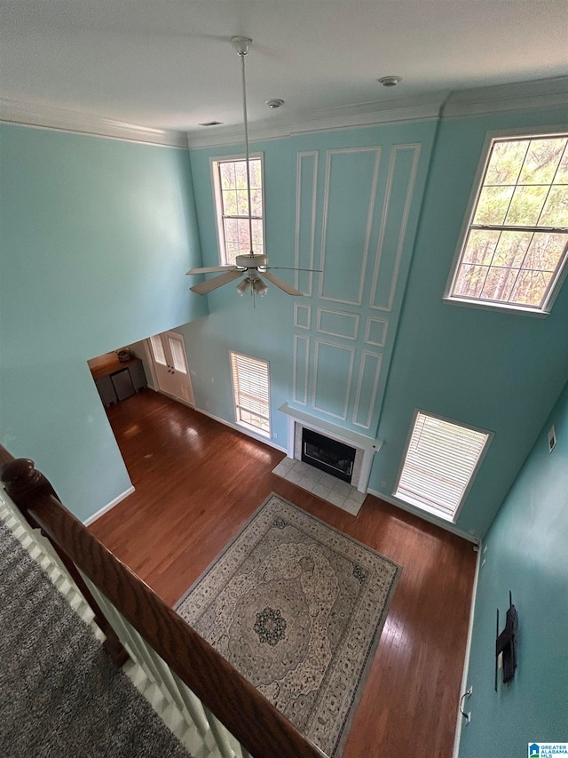 unfurnished living room with ceiling fan, ornamental molding, and hardwood / wood-style flooring