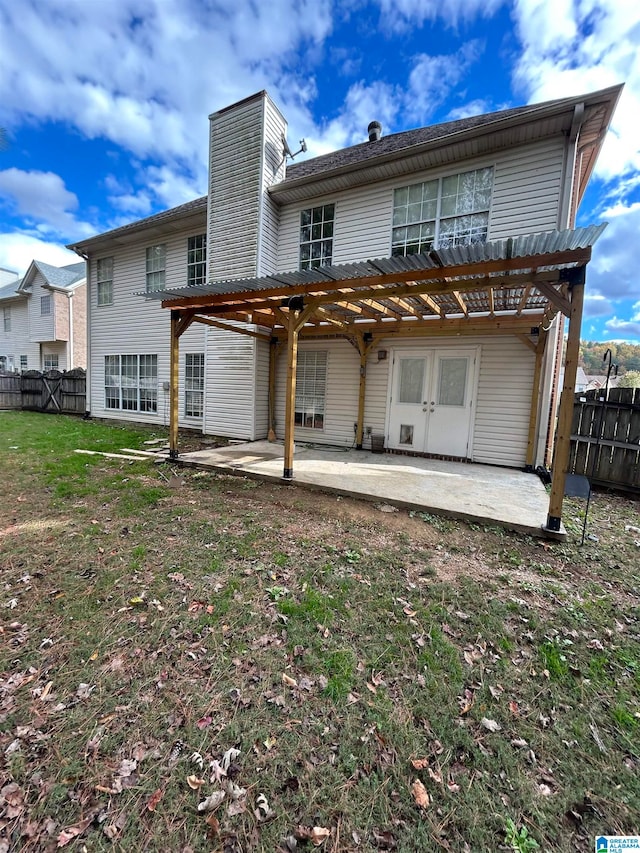 rear view of property featuring a patio area, a pergola, and a yard