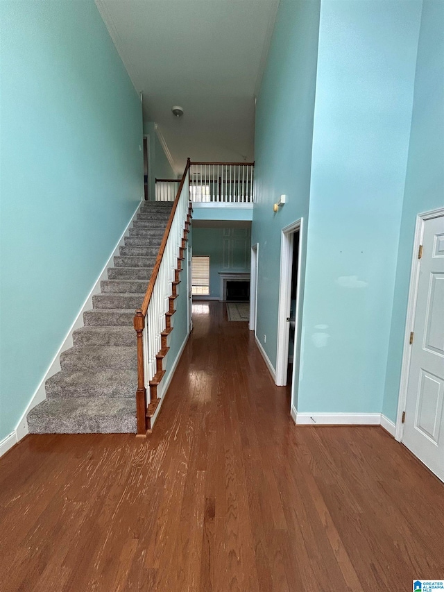 staircase featuring hardwood / wood-style floors and a towering ceiling