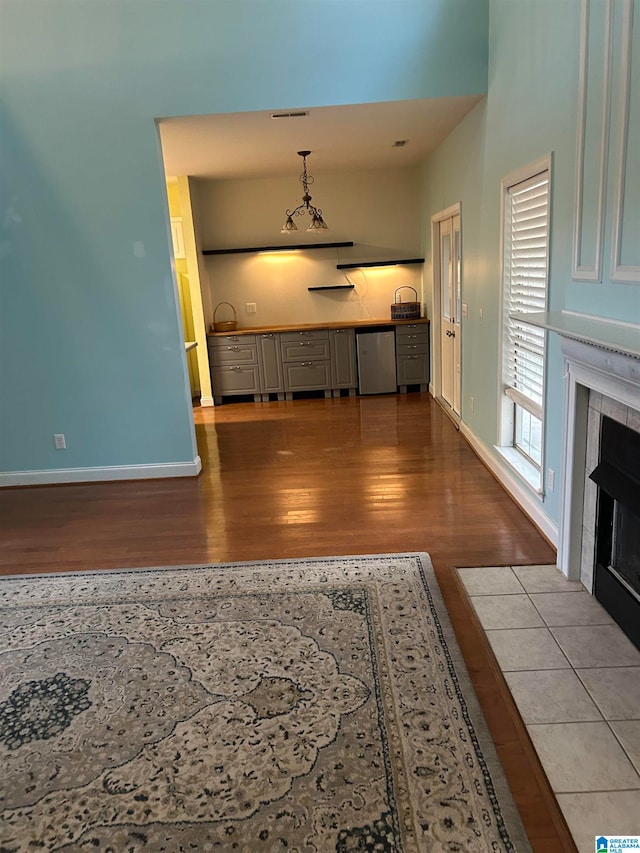 unfurnished living room featuring a fireplace, light hardwood / wood-style floors, and an inviting chandelier