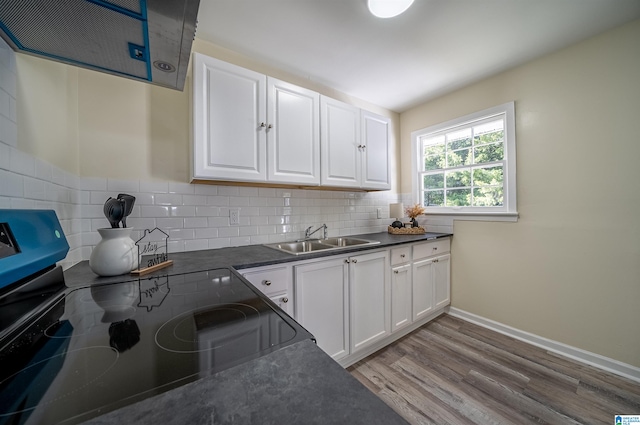 kitchen featuring white cabinetry, sink, decorative backsplash, and light wood-type flooring