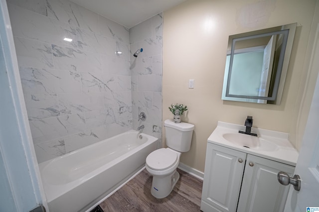 full bathroom with tiled shower / bath combo, vanity, hardwood / wood-style flooring, and toilet