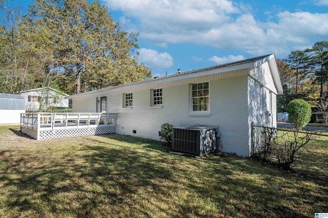 back of property featuring a wooden deck, central AC, and a lawn