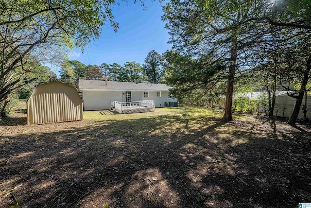 back of house featuring a deck and a shed