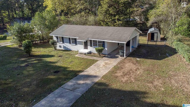 ranch-style house with a storage shed and a front yard