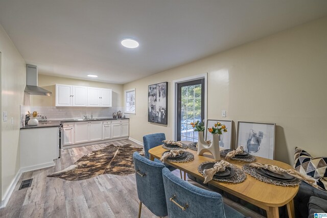 dining space with sink and light wood-type flooring