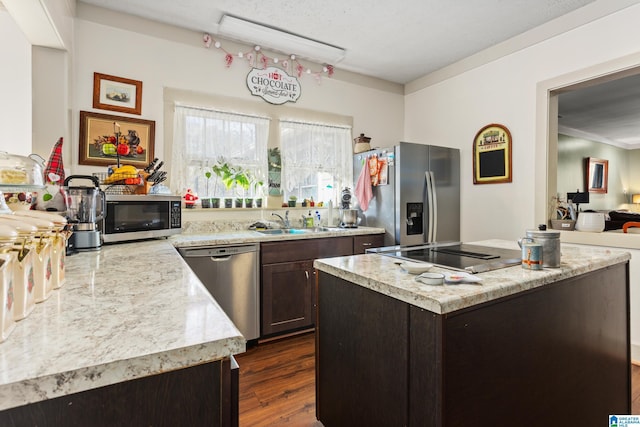 923 Cogswell Ave, Pell City, AL 35125 - kitchen featuring stainless steel appliances, a sink, dark brown cabinets, dark wood-style floors, and a center island