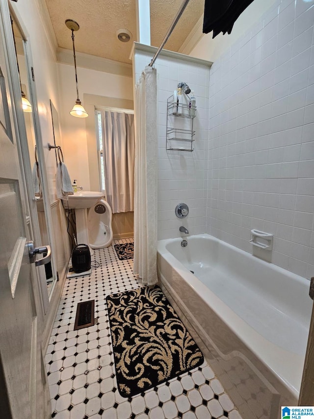 bathroom with tile patterned floors, a textured ceiling, crown molding, and shower / bath combo with shower curtain