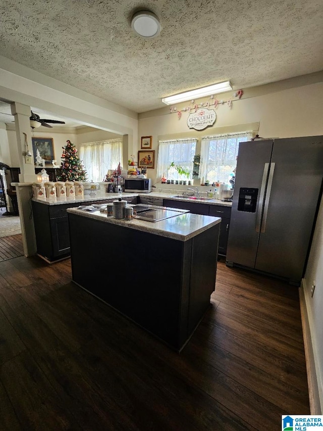 kitchen with a center island, dark wood-type flooring, and appliances with stainless steel finishes