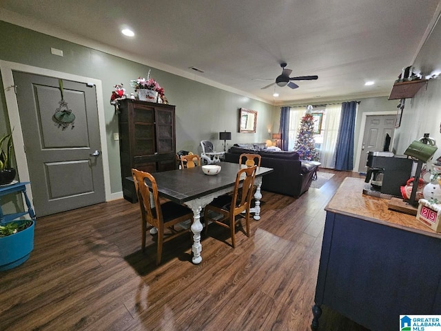 dining space featuring a wood stove, ceiling fan, and dark wood-type flooring