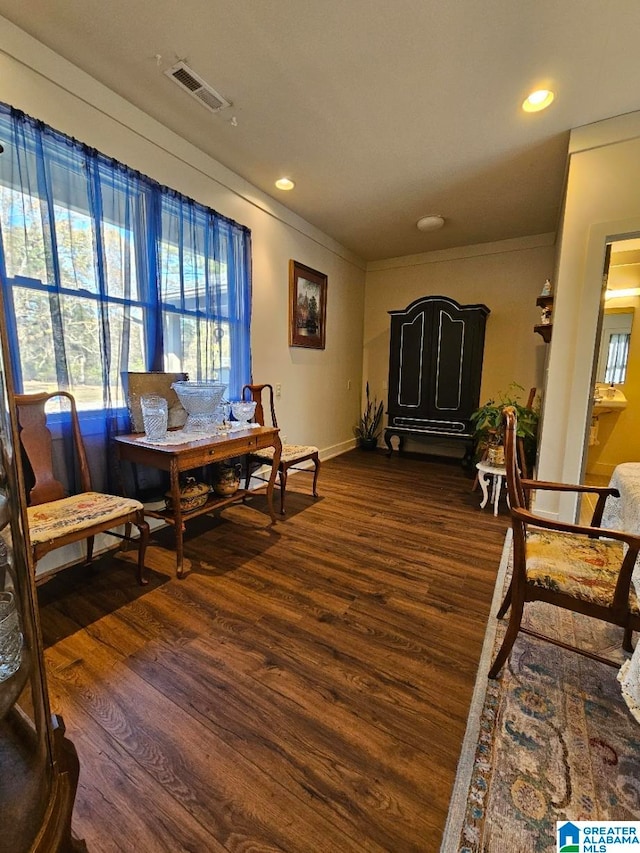 living area featuring dark hardwood / wood-style floors and crown molding