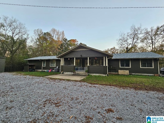 single story home featuring a porch, a patio, and central AC unit