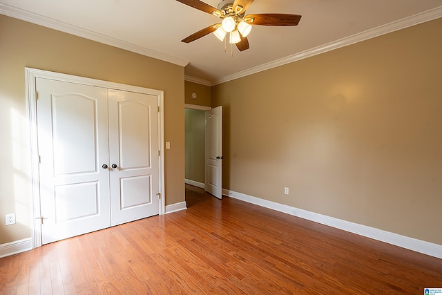 unfurnished bedroom with a closet, ceiling fan, light hardwood / wood-style flooring, and crown molding