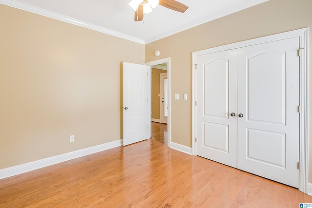 unfurnished bedroom with light wood-type flooring, a closet, ceiling fan, and ornamental molding