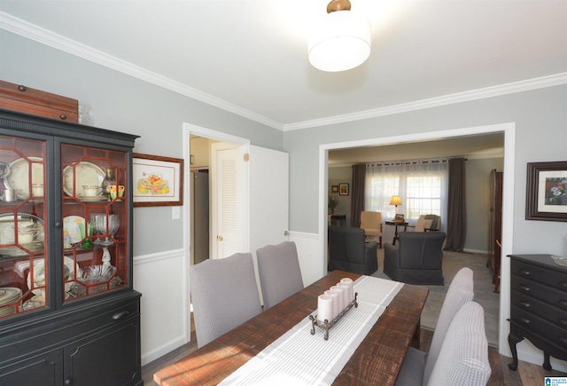 dining area with crown molding and dark wood-type flooring