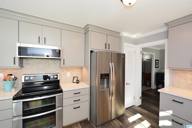 kitchen featuring backsplash, gray cabinetry, dark hardwood / wood-style flooring, and stainless steel appliances