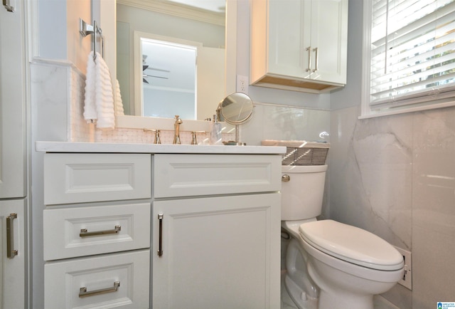 bathroom featuring vanity, toilet, tile walls, and crown molding