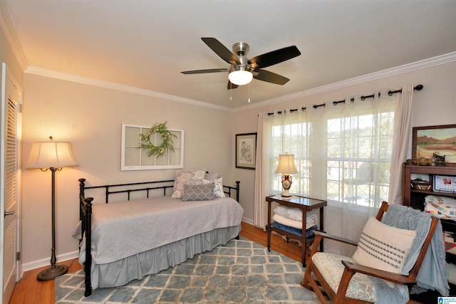 bedroom featuring hardwood / wood-style floors, ceiling fan, and crown molding