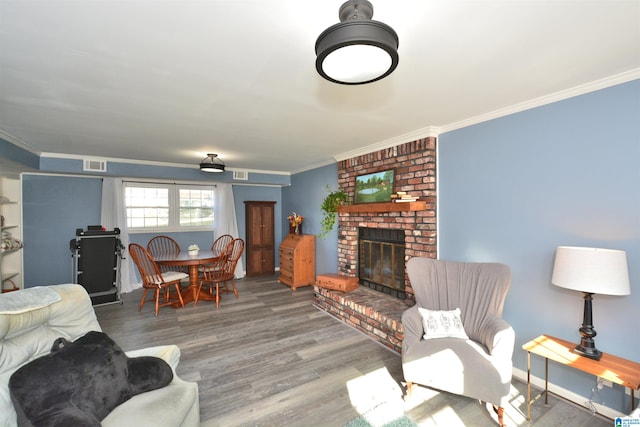 living room with a fireplace, wood-type flooring, and crown molding