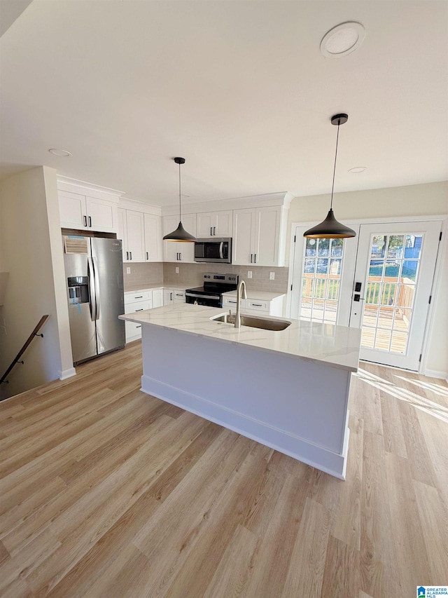 kitchen featuring white cabinetry, sink, hanging light fixtures, and appliances with stainless steel finishes