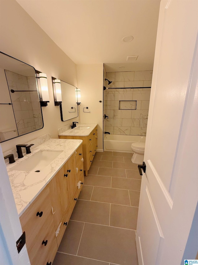 full bathroom featuring tile patterned flooring, vanity, toilet, and tiled shower / bath