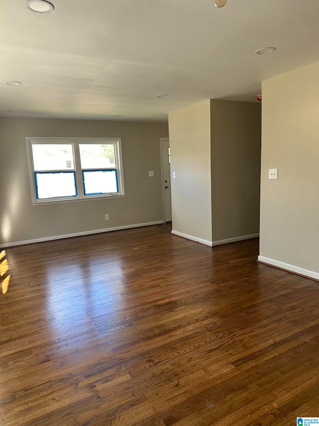 empty room with dark hardwood / wood-style flooring