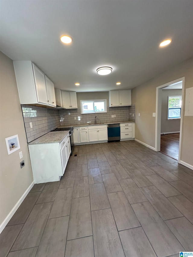 kitchen with stainless steel dishwasher, light hardwood / wood-style floors, white cabinets, and a wealth of natural light