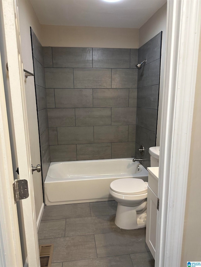 full bathroom with vanity, tiled shower / bath combo, and toilet