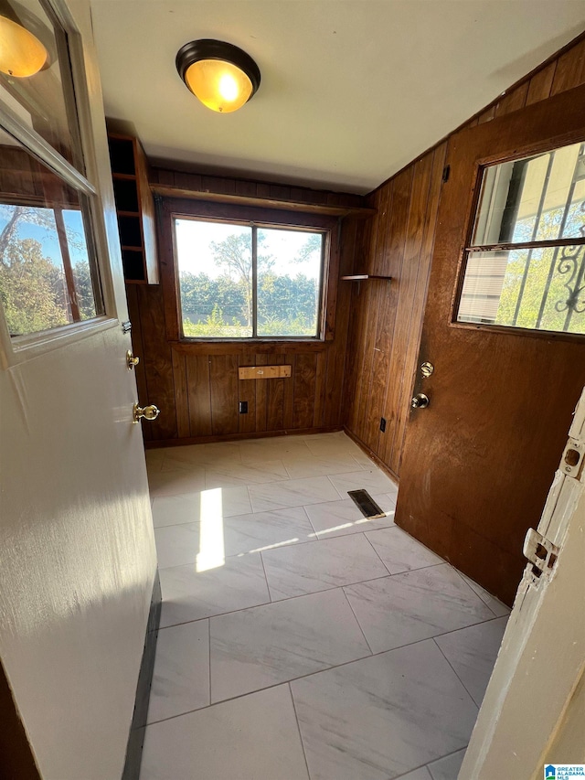 entryway with wooden walls