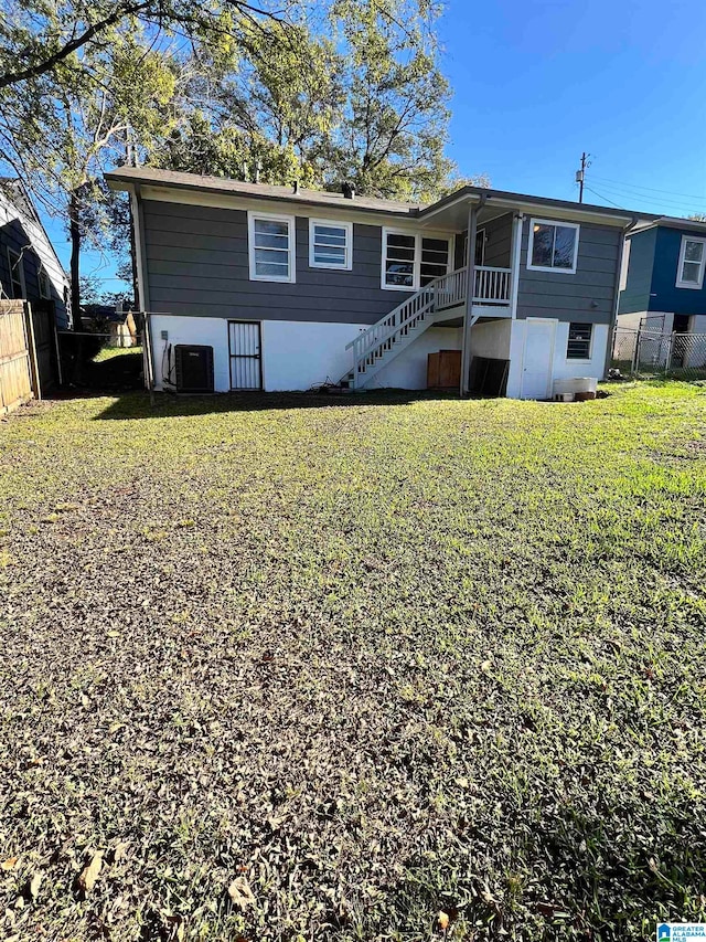 back of property featuring a lawn and central AC