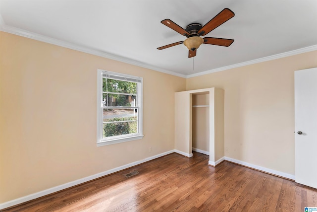 unfurnished bedroom featuring hardwood / wood-style flooring, ceiling fan, and crown molding