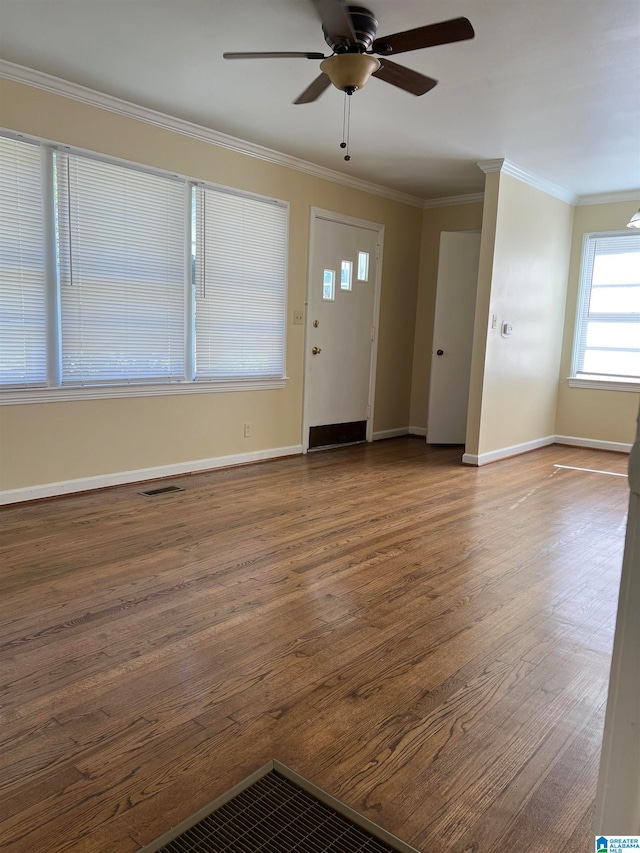 foyer entrance featuring hardwood / wood-style floors, ceiling fan, and crown molding