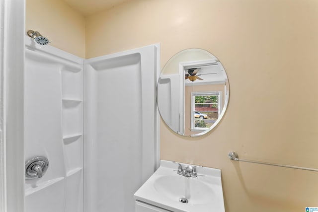 bathroom with vanity, ceiling fan, and a shower