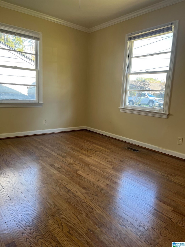 empty room featuring ornamental molding and dark wood-type flooring