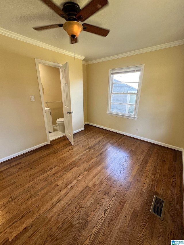 unfurnished bedroom with ceiling fan, wood-type flooring, crown molding, and ensuite bath