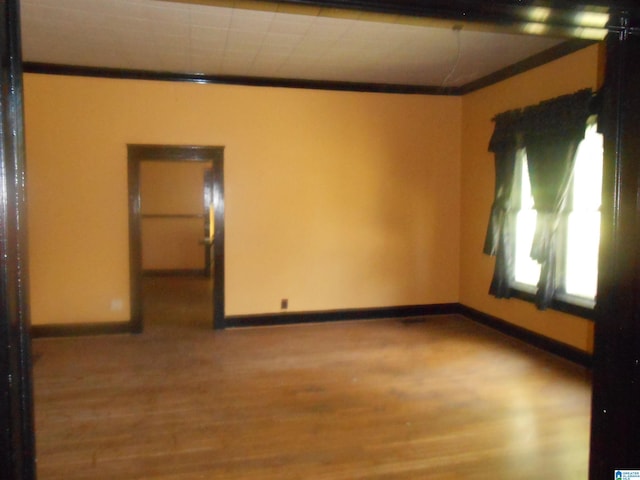 empty room with light wood-type flooring and ornamental molding