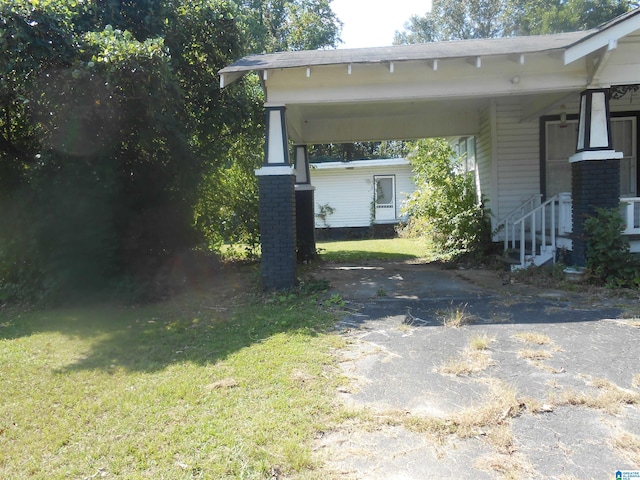 view of side of property featuring a yard and a carport