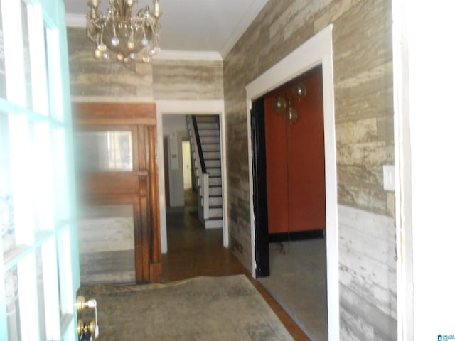 hallway with plenty of natural light, a chandelier, and ornamental molding