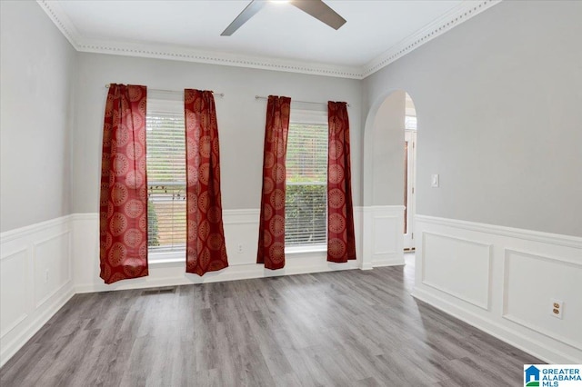 empty room featuring hardwood / wood-style floors, a wealth of natural light, and crown molding