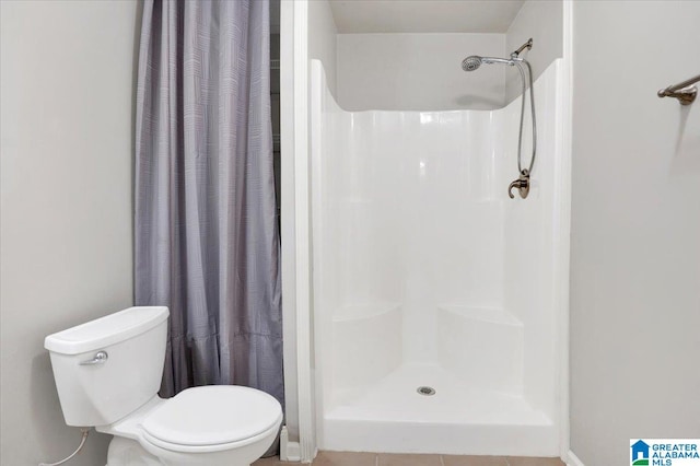 bathroom with tile patterned flooring, a shower with curtain, and toilet